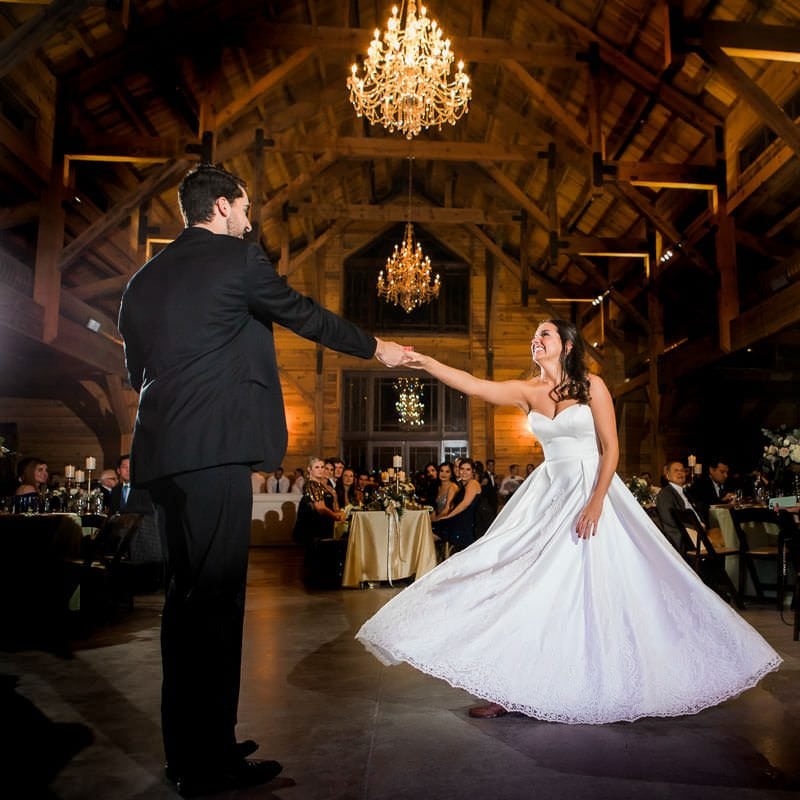Groom twirls his bride as they share their first dance