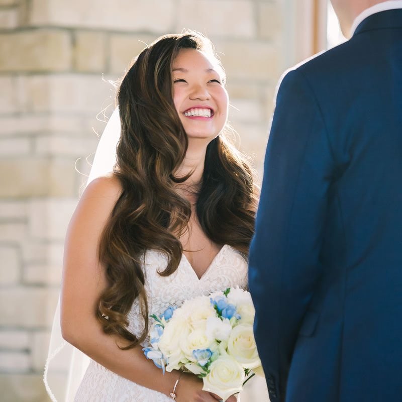 bride smiles at groom at their wedding ceremony