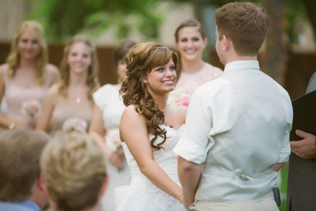 The bride looks at the groom while saying their vows during the wedding ceremony at Oak Tree Manor.