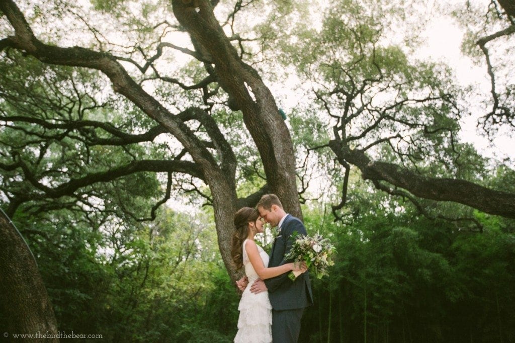 Bride and groom under the trees at Mercury Hall in Austin, TX.