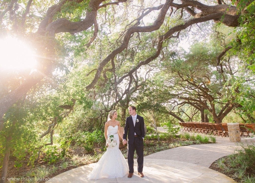 Bride and groom stand in the sunshine at Sacred Oaks Camp Lucy in Dripping Springs, TX.