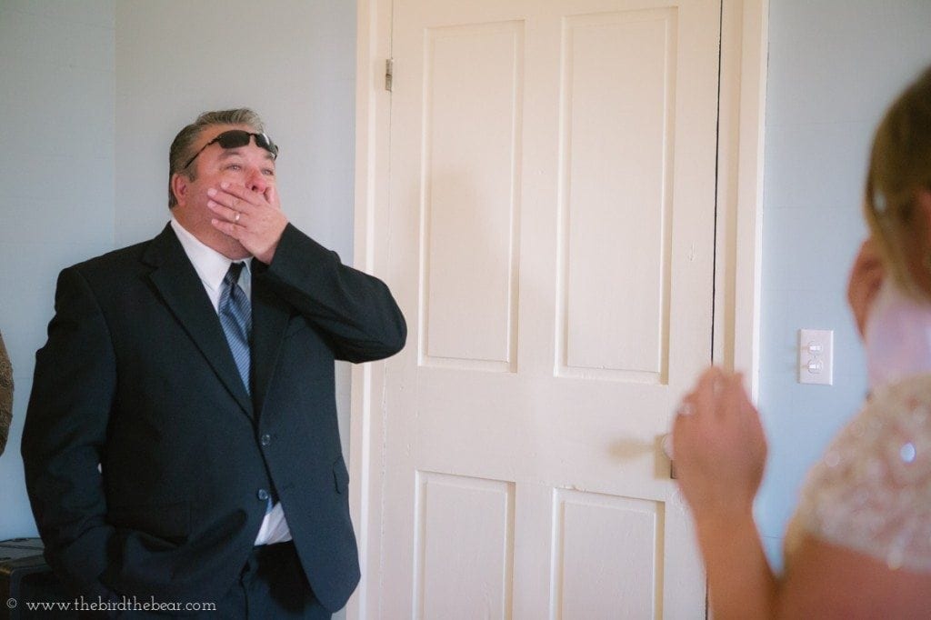 Father of the bride sees his daughter in her wedding dress for the first time.