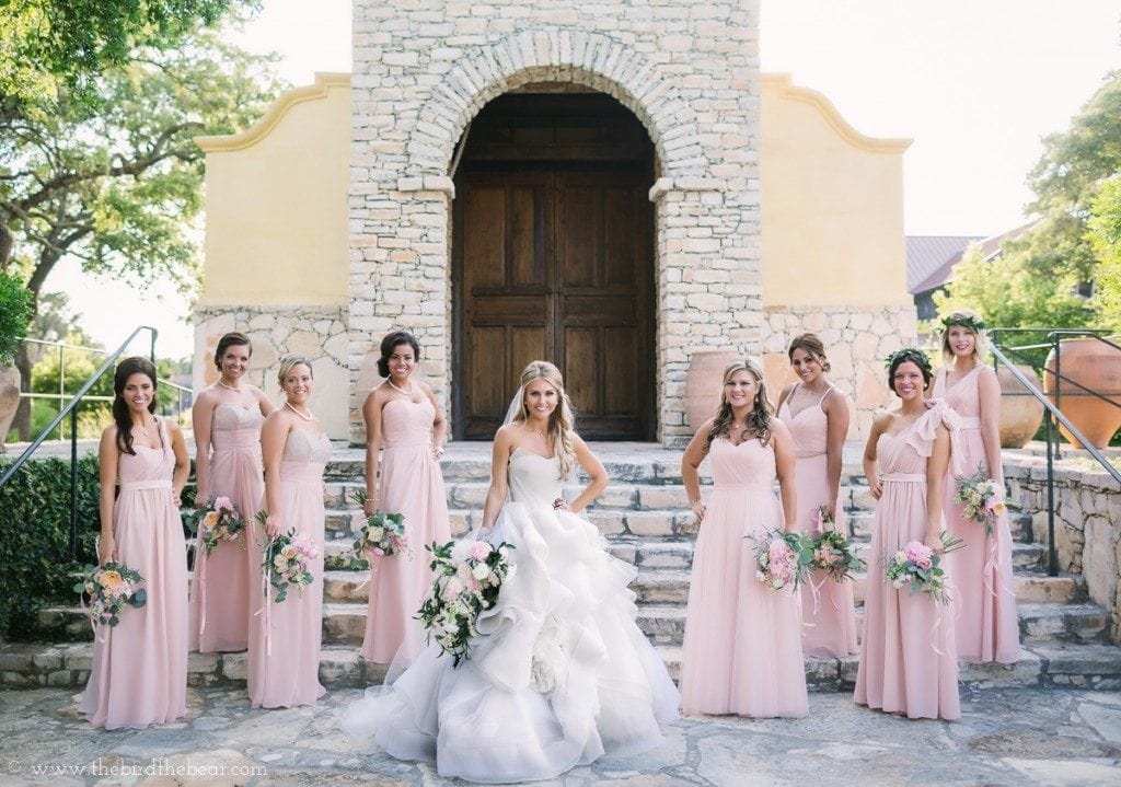 Bridesmaids in blush pink bridesmaids dresses with bride in vera wang bridal gown.