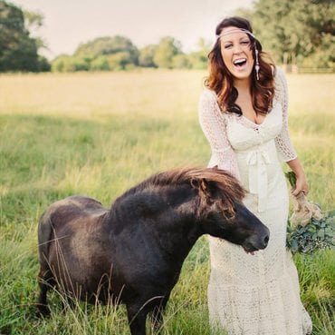 Bride laughs while standing next to a horse, Austin wedding photography