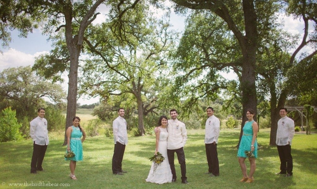 The bridal party stands on the lawn at Pecan Springs Ranch