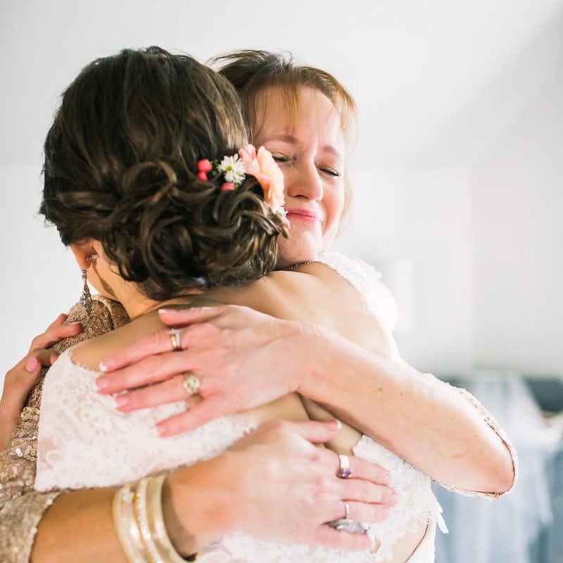 mother embraces her daughter before wedding ceremony