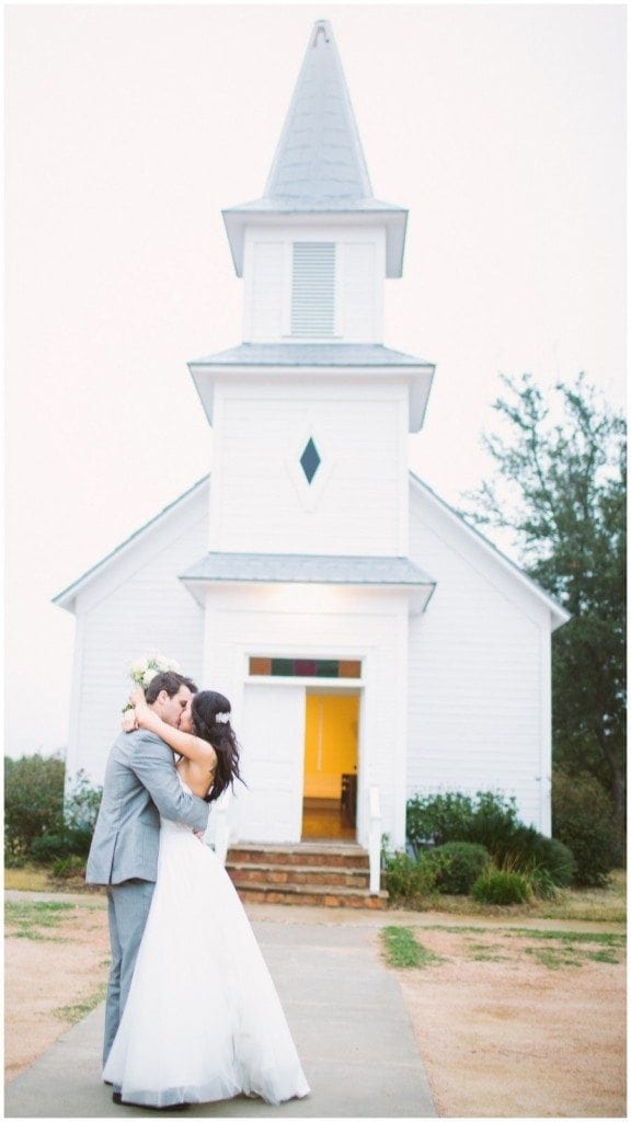 Bride and groom kiss in front of the small Star Hill Ranch chapel.