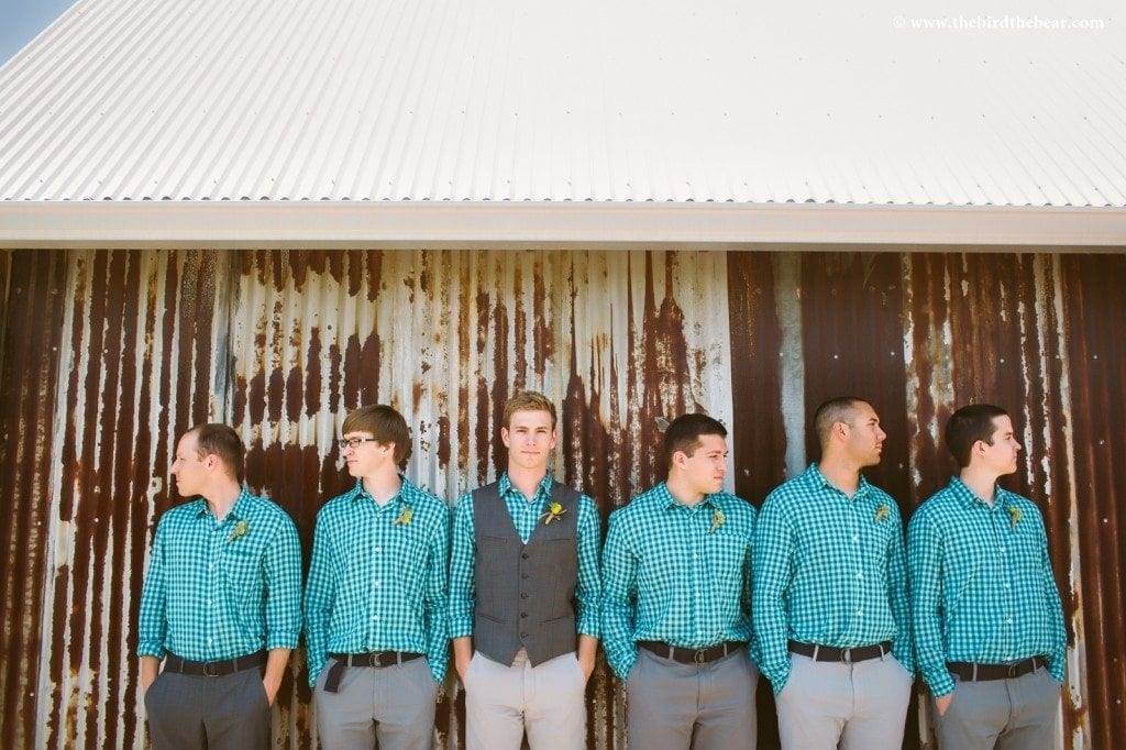 A groom and groomsmen stand at the Heritage House.