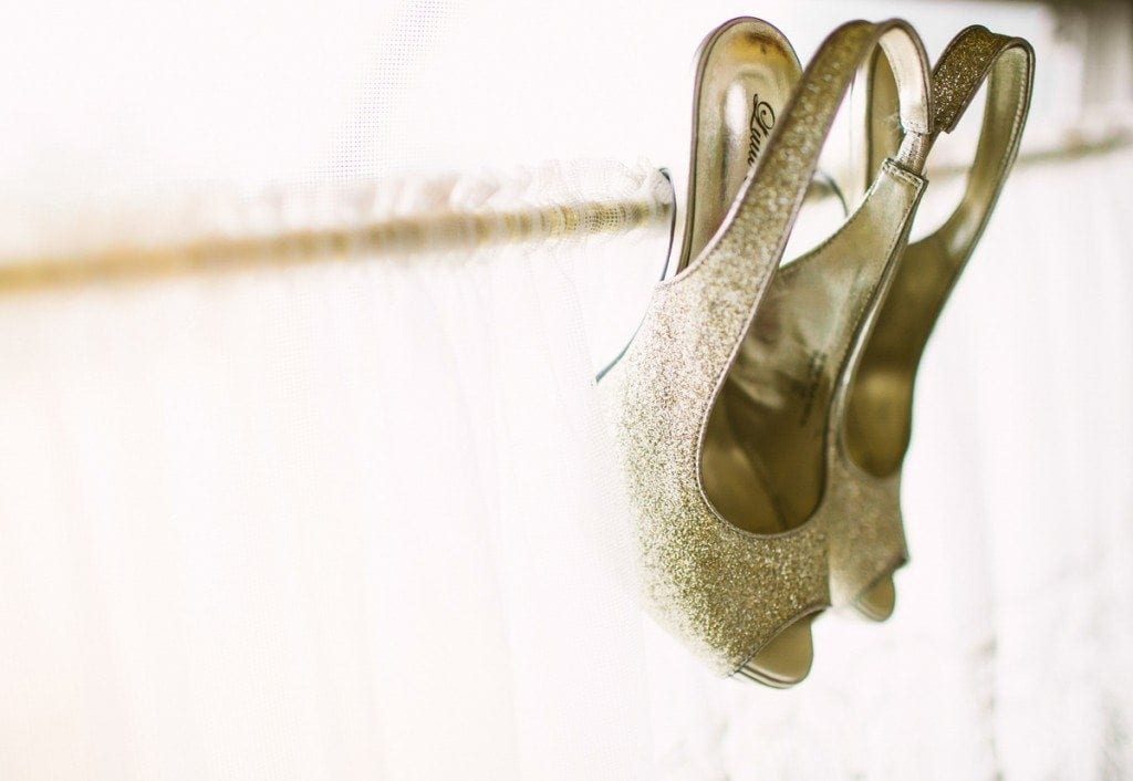 Bride's shoes hang from the window of a vintage airstream trailer at Three Points Ranch wedding venue in Dripping Springs, TX.