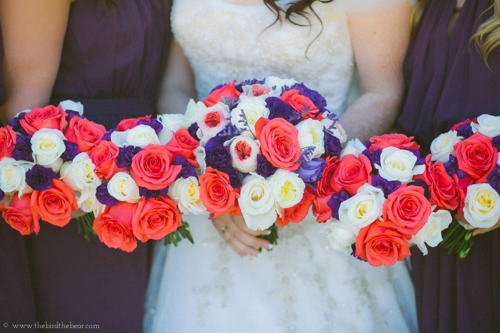 Bridesmaids hold their red and purple flowers before the wedding ceremony at Gabriel Springs.