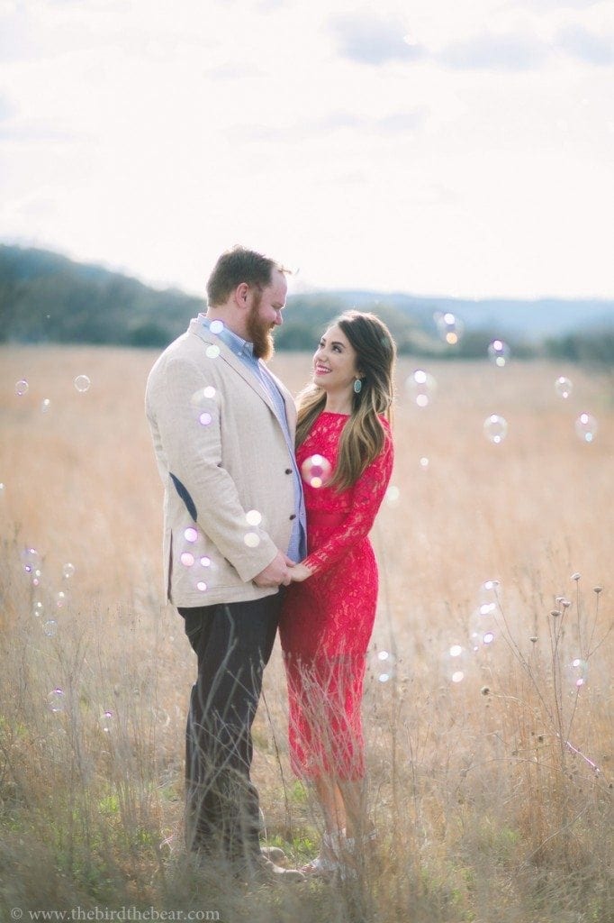 Creative engagement photos with bubbles and a hot pink dress in Austin, TX