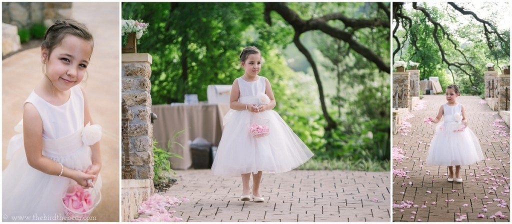 The flower girl drops pink rose petals down the aisle.