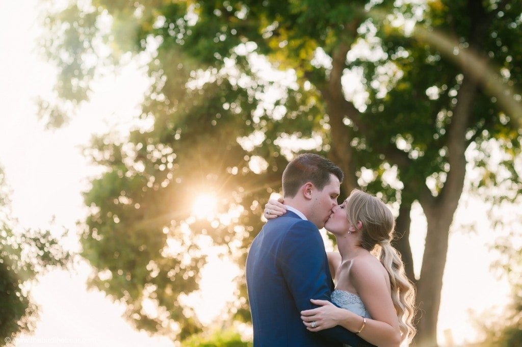Bride and groom kiss at sunset at Barr Mansion in Austin, TX