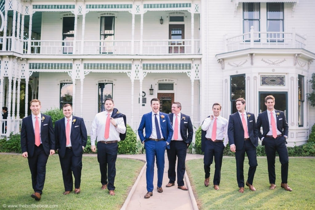 Groom and Groomsmen laugh as they walk outside of beautiful house