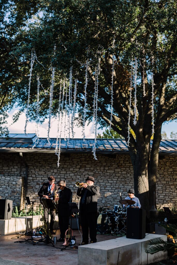 Cocktail hour with lights hanging from trees at Lakeway Resort wedding