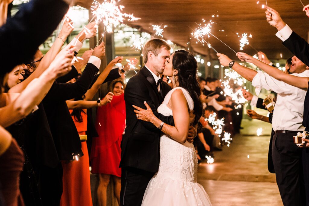 Bride and groom kissing among sparklers as part of a Lakeway Resort wedding