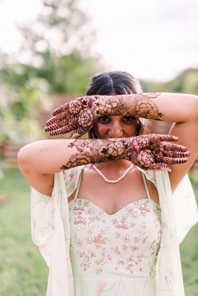 Bride posing with henna on arms in prep for Maes Ridge wedding