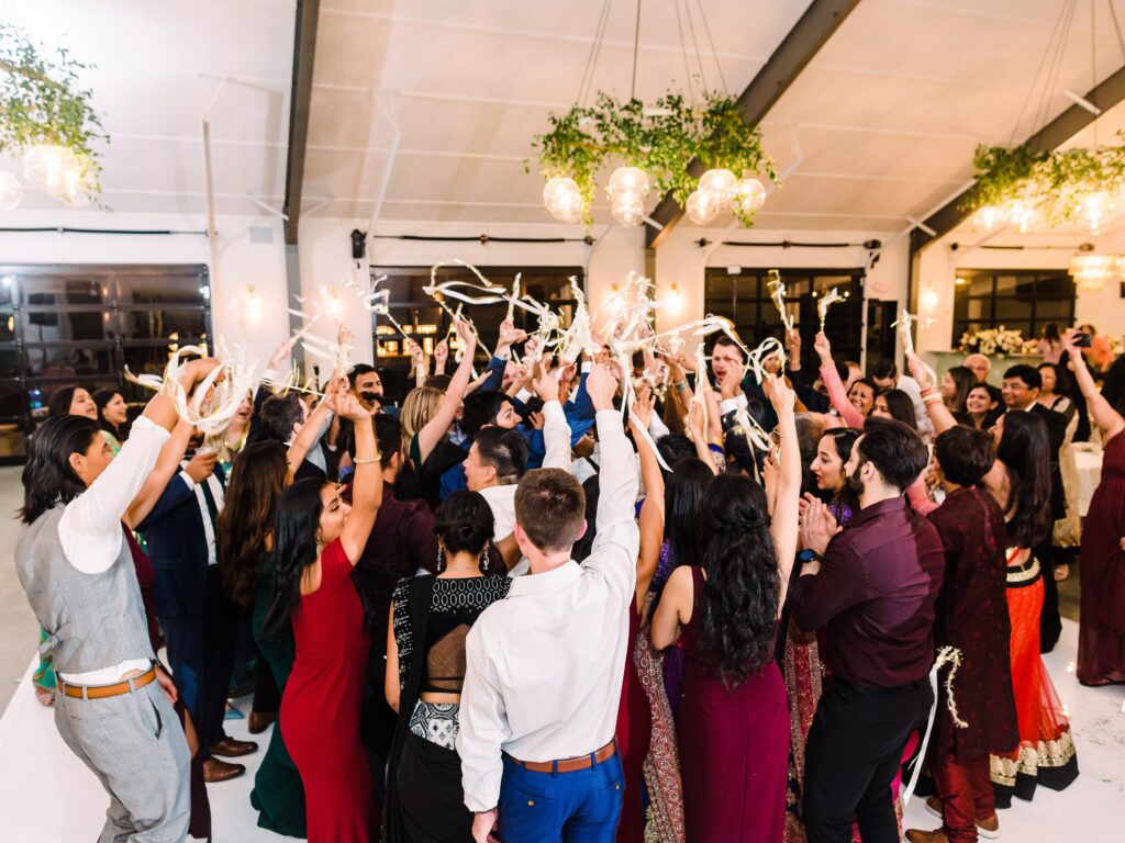 Guests waving ribbon wands on dance floor at Maes Ridge wedding reception