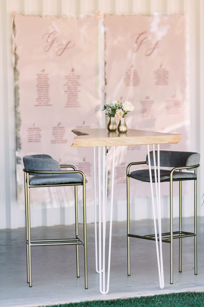 Tall elegant cocktail tables with pink seating chart at Maes Ridge wedding cocktail hour